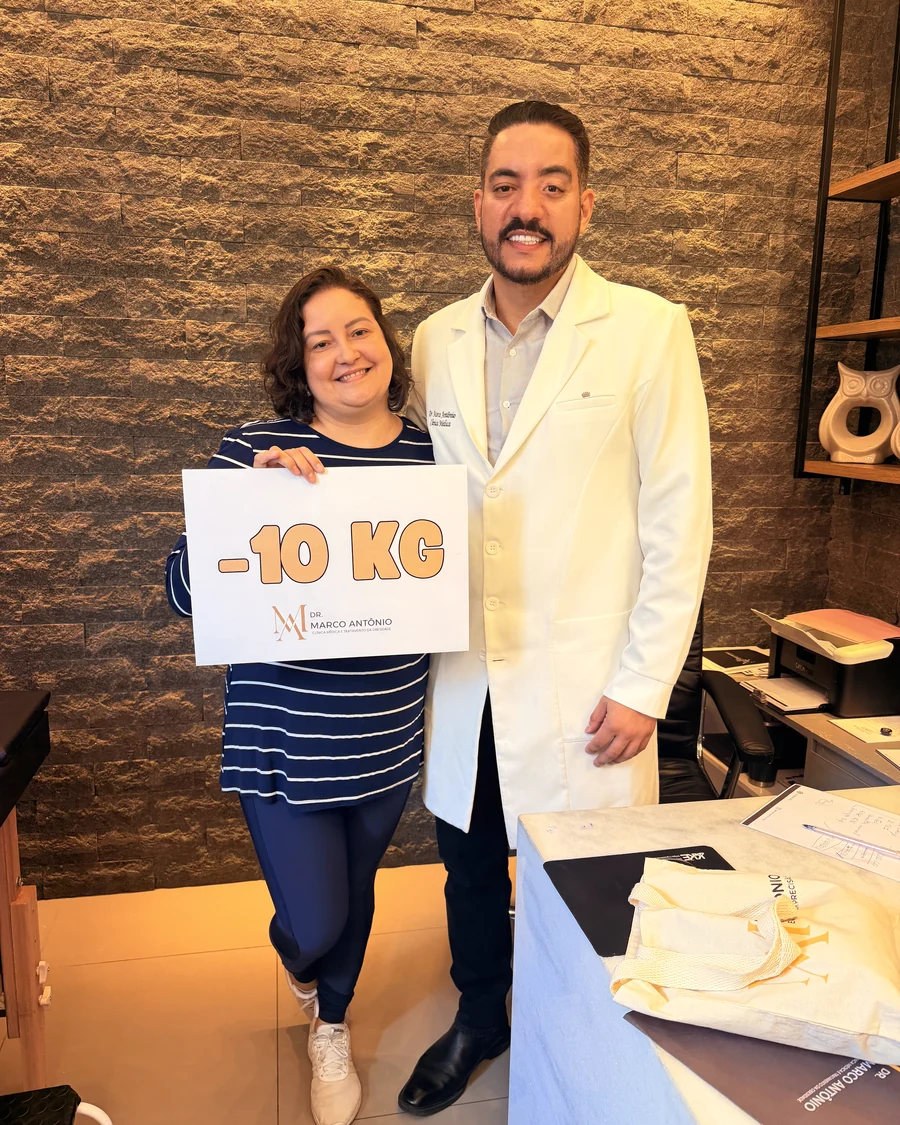 Paciente ao lado do Dr. Marco Antônio segurando uma placa de menos 10 quilos